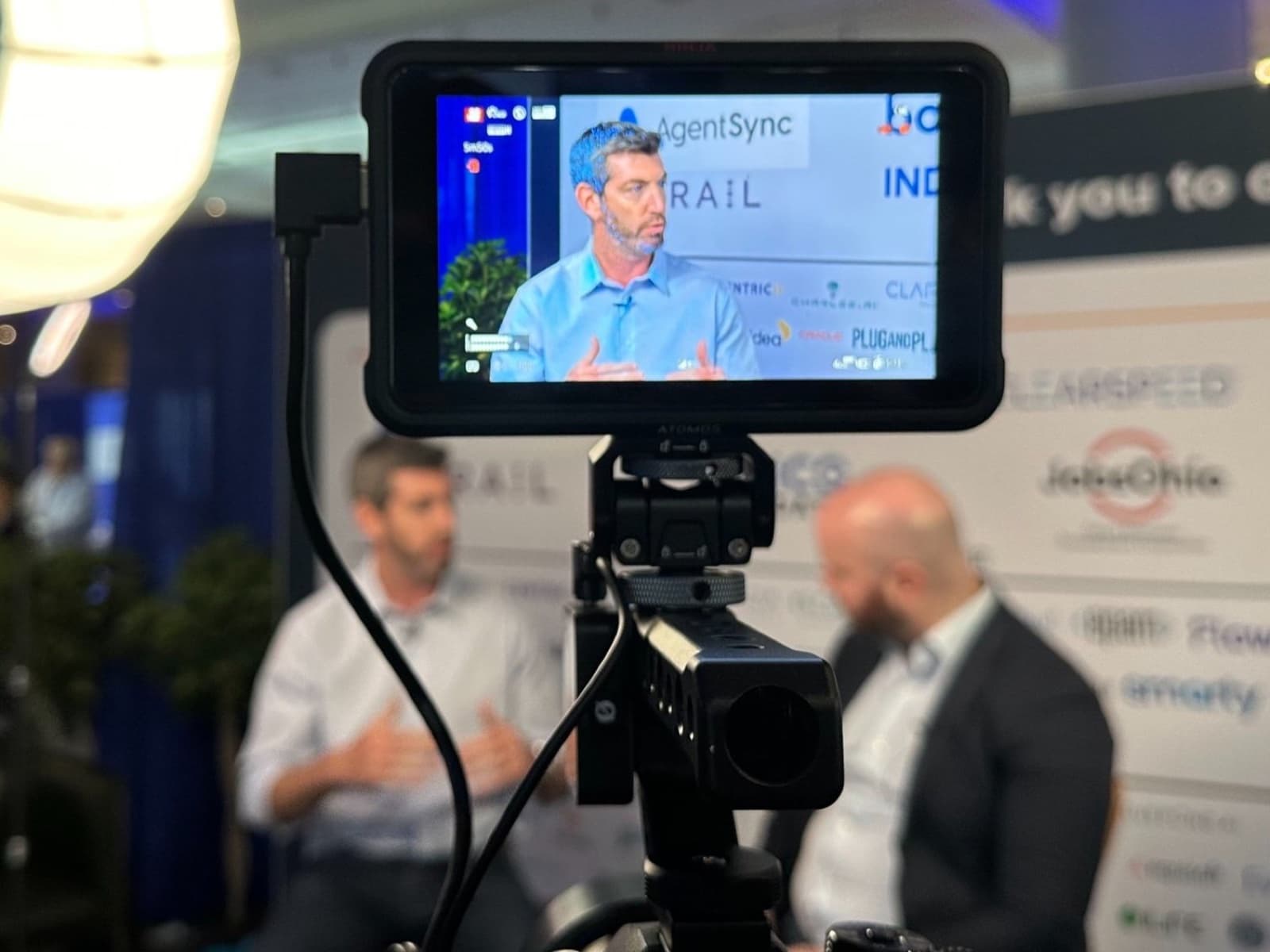 Monitor on a camera rig framing an interview subject at a conference