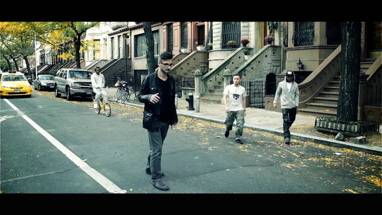 A man walking down the middle of a quiet brownstone street, from Stop Motion